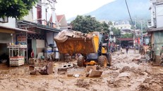 Máy xúc được huy động để hỗ trợ san gạt, thu gom bùn đất, cành cây, rác bị tràn về trong đợt lũ vừa qua tại xã Sông Mã. Ảnh: Quang Quyết