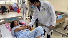 Bác sĩ Trần Văn Khanh - Giám đốc Bệnh viện Quận 2 đang thăm hỏi bệnh nhân vừa qua cơn nguy kịch do đột quỵ não. Ảnh: Ngọc Giàu 