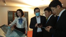 Các khách mời đang thử nghiệm ứng dụng mới của EVNHANOI. Ảnh: LĐO