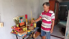 Ông Nguyễn Minh Tuấn (cha của cháu Nguyễn Hoàng Minh) đứng trước di ảnh của con, 