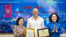 Nguyên Phó Chủ tịch nước Trương Mỹ Hoa (bìa trái) chúc mừng NSNA Nguyễn Á nhận tước hiệu Nghệ sĩ Nhiếp ảnh đặc biệt xuất sắc (E.VAPA/G)