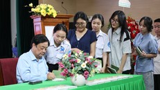 Tác giả Lê Minh Hoan (bút danh Xích Lô) ký tặng lên sách “Mỗi nghề một bông hoa” cho bạn đọc. Ảnh: Trung Nghĩa
