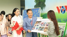 Hoa hậu Miss Charm Vietnam 2026 Nguyễn Ngọc Trà My (áo dài) thích thú xem ảnh chủ đề “Tắt điện thoại, mở sách ra” của sinh viên Trường CĐ Phát thanh - Truyền hình II. Ảnh: Nguyễn Đặng Thanh Ngân