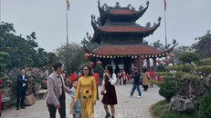 Du khách đi lễ Phật và thưởng lãm sắc Xuân nơi cửa Phật tại chùa Tảo Sách (quận Tây Hồ). Ảnh: Đinh Thuận/TTXVN.