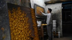 Một hoạ sĩ đang vẽ tranh tại nhà xưởng ở làng Dafen, Trung Quốc.