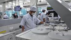 Nhân viên y tế Bệnh viện Chợ Rẫy vận hành hệ thống máy xét nghiệm. Ảnh: Đinh Hằng/TTXVN.