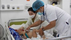 Bác sỹ thăm khám cho một bệnh nhi mắc tay chân miệng. Ảnh: Phan Sáu/TTXVN.