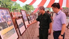 Khách tham quan hào hứng xem các ảnh, tư liệu được trưng bày tại Triển lãm. Ảnh: Chu Hiệu/TTXVN.