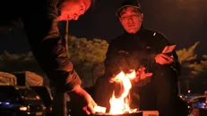 Người dân sưởi ấm gần cầu Long Biên khi nhiệt độ giảm chỉ khoảng 10 độ. Ảnh: Hoàng Hiếu/TTXVN.