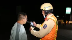 Cảnh sát giao thông kiểm tra nồng độ cồn đối với tài xế xe ôtô. Ảnh: Hữu Chí/TTXVN.