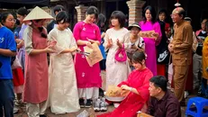 Du khách Hàn Quốc trải nghiệm làm tranh Đông Hồ ở Hà Nội. Ảnh: Mai Mai/TTXVN.