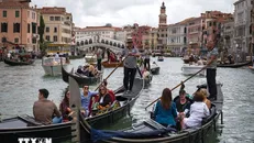 Du khách đi thuyền gondola tại Venice, Italy. Ảnh: AFP/TTXVN.