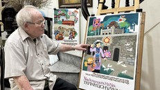 Họa sĩ Trần Duy Trúc bên những bức tranh cổ động.