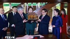 hủ tướng Phạm Minh Chính tặng Thủ tướng Kyrgyzstan Adylbek Kasimalyev mô hình nhà sàn Bác Hồ. Ảnh: Dương Giang/TTXVN