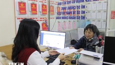 Cán bộ phường hướng dẫn người dân làm thủ tục hành chính. Ảnh: Nguyễn Thắng/TTXVN.