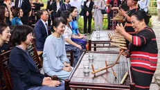 Nghệ nhân ưu tú Y Sinh giới thiệu nét văn hoá dân tộc Xơ Đăng với bà Ishiba Yoshiko, Phu nhân Thủ tướng Nhật Bản. Ảnh: Minh Đức/TTXVN.