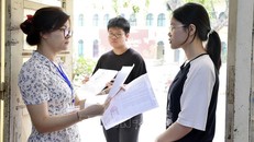 Giám thị gọi thí sinh vào phòng thi tại điểm thi Trường THPT Việt Đức (quận Hoàn Kiếm). Ảnh tư liệu: Nguyễn Cúc/TTXVN.