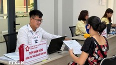 Cán bộ, chuyên viên từ Thành phố Hồ Chí Minh được "biệt phái" xuống xã để tiếp nhận hồ sơ "phi địa giới" hành chính. Ảnh: Hữu Duyên/TTXVN.