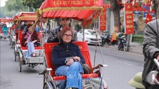 Du khách nước ngoài thích thú với khí hậu mát lạnh và trải nghiệm đi xích lô giữa không gian Thủ đô yên bình. Ảnh: Phan Phương/TTXVN.