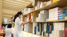 Nhân viên y tế cấp phát thuốc bảo hiểm y tế cho người bệnh.