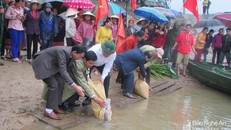 Lãnh đạo huyện Con Cuông và chính quyền địa phương tham gia thả cá xuống sông Giăng. 