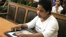 Người thân mang di ảnh nạn nhân đến tòa. (Ảnh PLO)