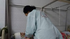 Bà Vân bón từng thìa thức ăn cho con dâu bị bỏng nặng.