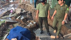 Lực lượng chức năng hỗ trợ người dân di dời tài sản ra khởi khu vực sụt lún nguy hiểm. 