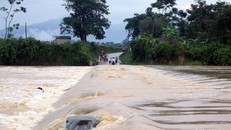 Sau những cơn mưa to, đập tràn cạnh bản Hoa Tiến 1 biến thành dòng sông lớn, nước chảy cuồn cuộn gây trở ngại cho người và phương tiện qua lại. Mỗi ngày, cư dân ở hai bản Hoa Tiến 1 và Hoa Tiến 2 với tổng cộng 371 hộ phải qua lại trên con đập này. Ảnh: Hữ