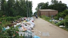 Rác ùn ứ nhiều ngày đã tràn ngập đường đi khi người dân chặn xe chở rác. Ảnh: Đinh Hương/TTXVN