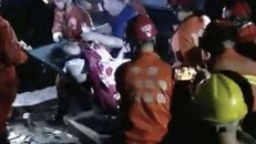 Lực lượng cứu hộ khiêng những người sống sót ra khỏi khu vực đổ nát sau hai trận động đất mạnh ở phía Tây Nam Trung Quốc