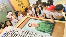 Các em học sinh hào hứng tham quan quyển sách thư pháp viết về Đại tướng Võ Nguyên Giáp.