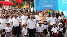 Lãnh đạo Chính phủ và các Bộ, ban ngành đi bộ kêu gọi toàn dân đội mũ bảo hiểm cho trẻ em khi tham giao giao thông. (Ảnh: Việt Hùng/Vietnam+)