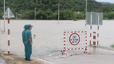 Lực lượng chức năng trực chốt tại khu vực cấm người dân qua tuyến đường DT642 thị trấn La Hai, huyện Đồng Xuân (Phú Yên) bị ngập do nước lũ. Ảnh: Phạm Cường/TTXVN