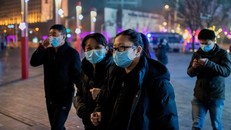 Người đi bộ ở Bắc Kinh đeo khẩu trang để ngăn ngừa virus corona mới. 