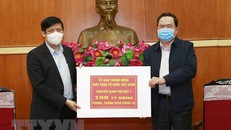 Chủ tịch Ủy ban Trung ương MTTQ Việt Nam Trần Thanh Mẫn trao tượng trưng kinh phí cho đại diện Bộ Y tế. (Ảnh: Doãn Tấn/TTXVN)