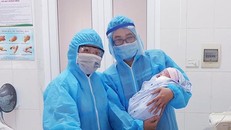 Các bác sĩ chụp ảnh cùng bé gái mới chào đời trong khu cách ly.