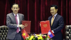 Thứ trưởng Bộ Ngoại giao Lê Hoài Trung và Bộ trưởng Ngoại giao Lào Saleumsay Kommasith trao đổi Biên bản cuộc họp. Ảnh: Phạm Kiên/Pv TTXVN tại Lào