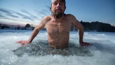 Tại Siberia, người dân đón năm mới bằng cách ngâm mình trong một hồ nước đóng băng trong khi bám chặt vào một thân cây được đặt dưới băng.