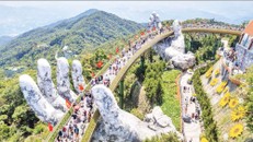 Du khách thưởng lãm khung cảnh công trình "Cầu Vàng" rợp bóng cờ đỏ sao vàng.