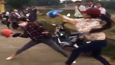 Hai nữ sinh dùng mũ bảo hiểm đánh nhau. Ảnh cắt từ clip.