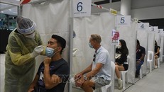 Nhân viên y tế lấy mẫu xét nghiệm COVID-19 cho người dân tại Singapore. Ảnh tư liệu: TTXVN