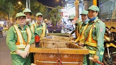 Các công nhân vệ sinh môi trường của Công ty Trách nhiệm hữu hạn Một thành viên Môi trường đô thị TP Hồ Chí Minh bắt đầu một ca làm việc đêm.