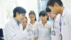 Lê Văn Tình (bìa trái) hướng dẫn sinh viên tại phòng thí nghiệm. Ảnh: Trường An.