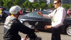 Ông Tây ra hiệu người đi xe máy dừng lại trên Xa lộ Hà Nội để nhường dòng xe đổ vào đường Võ Trường Toản. Ảnh: Sơn Hòa