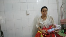 Chị Thành cùng cô con gái vừa chào đời mang ơn người anh em họ đã xả thân cứu mình. Ảnh: Nguyễn Đông.