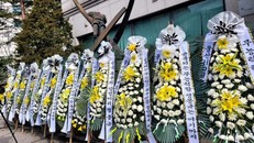 Trụ sở SM Entertaiment bao quanh bởi những chiếc hoa tang. Ảnh: Koreaboo.