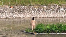 Cô gái cởi trần bơi ra giữa sông Tô Lịch. Ảnh: Soha.vn