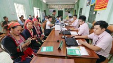 Bà con làm thủ tục vay vốn với cán bộ Ngân hàng Chính sách Xã hội. (Ảnh: CTV/Vietnam+)