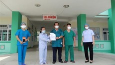 Đại diện lãnh đạo Bệnh viện Phổi Đà Nẵng trao giấy xuất viện cho bệnh nhân 445 mắc COVID-19. (Ảnh: Văn Dũng/TTXVN)